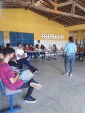 Grupo de pessoas sentadas em cadeiras

Descrição gerada automaticamente